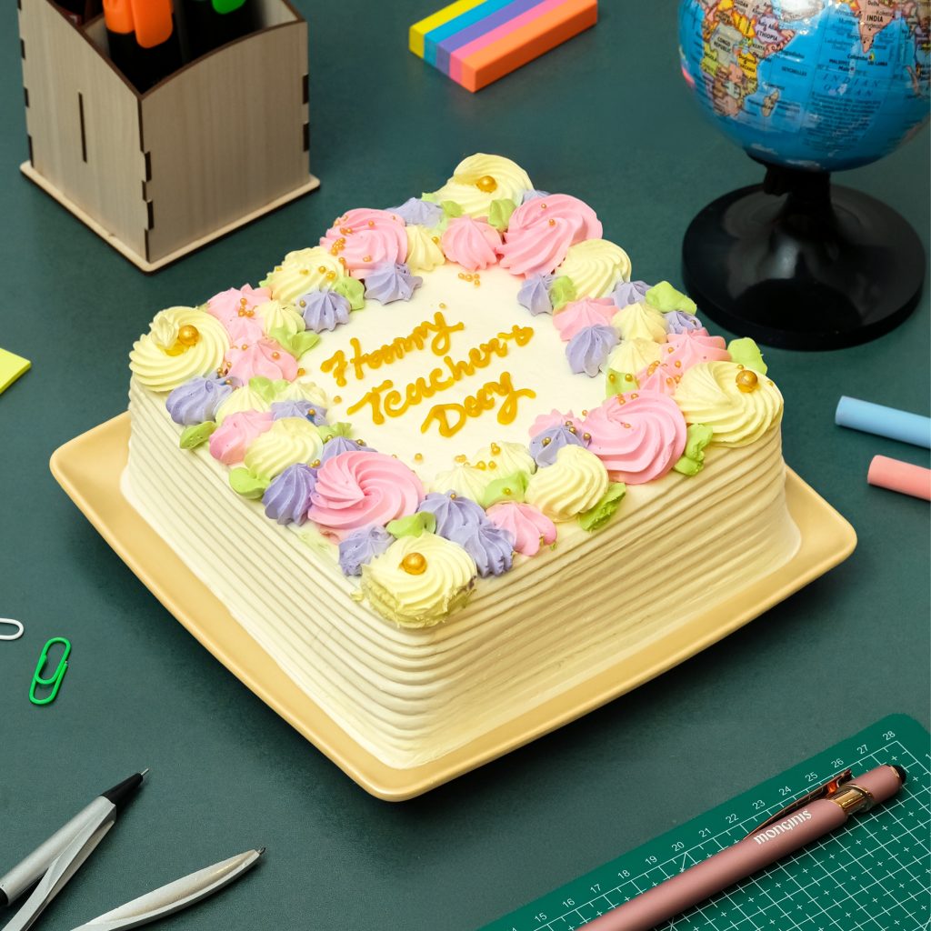 Square vanilla cake topped with colourful piped cream swirls